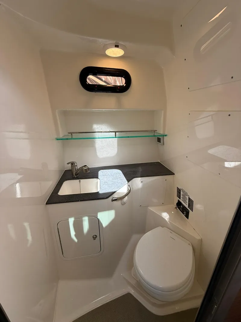 Slide: The Image of 2020 Boston Whaler 325 Conquest bathroom with sink, toilet, and shelf. - 19