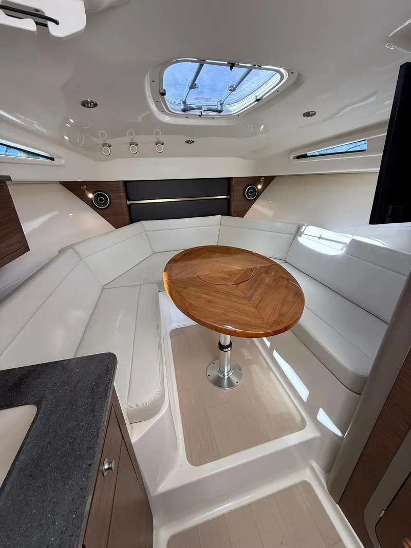 Slide: The Image of 2020 Boston Whaler 325 Conquest cabin with elegant seating and wooden table. - 21