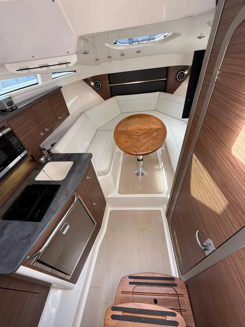 Slide: The Image of 2020 Boston Whaler 325 Conquest cabin interior with modern kitchen and seating area. - 26