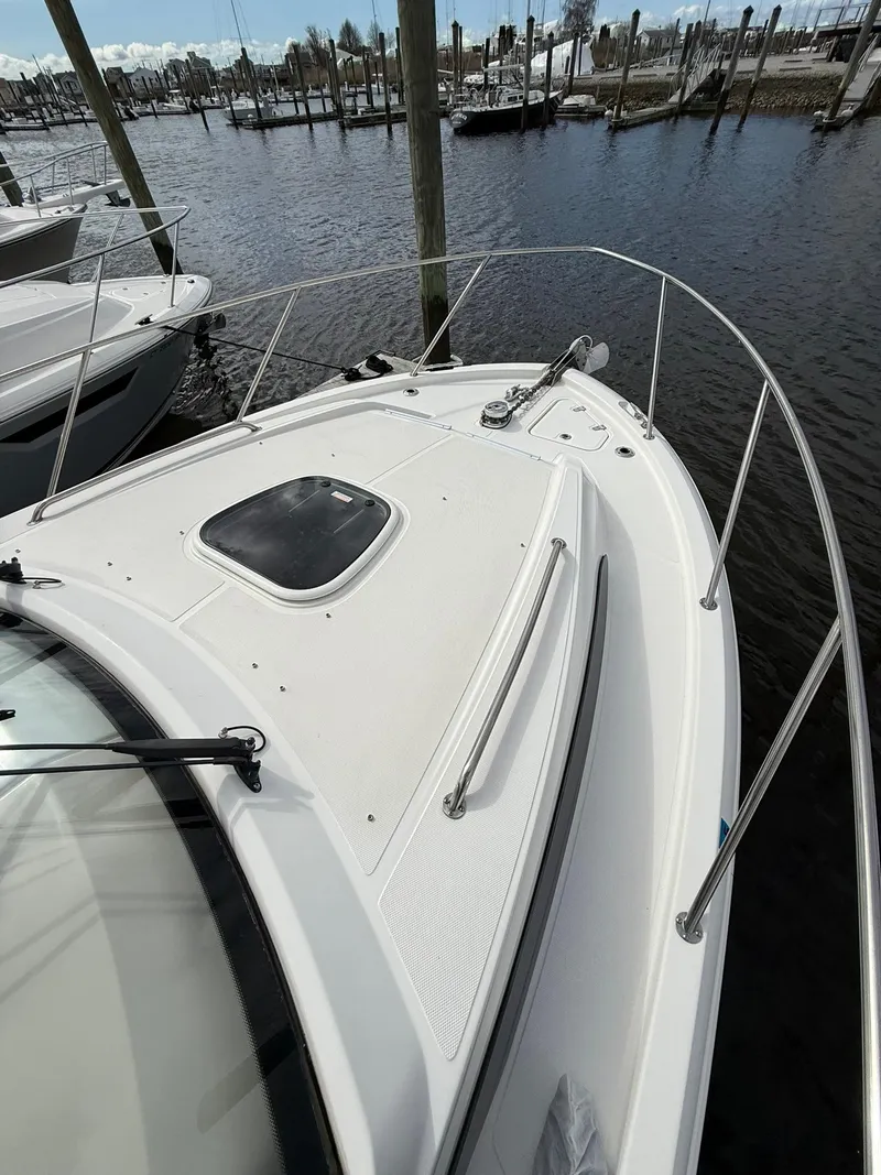 Slide: The Image of 2020 Boston Whaler 325 Conquest boat docked at marina, showcasing sleek bow design. - 30