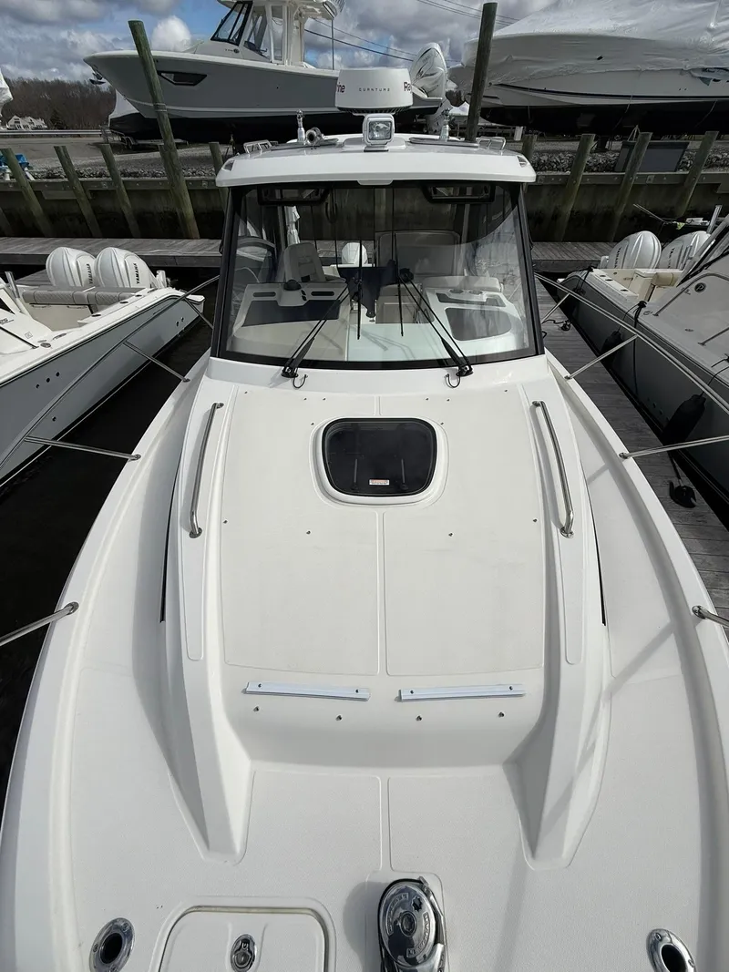 Slide: The Image of 2020 Boston Whaler 325 Conquest boat docked, showcasing sleek design and spacious deck. - 31