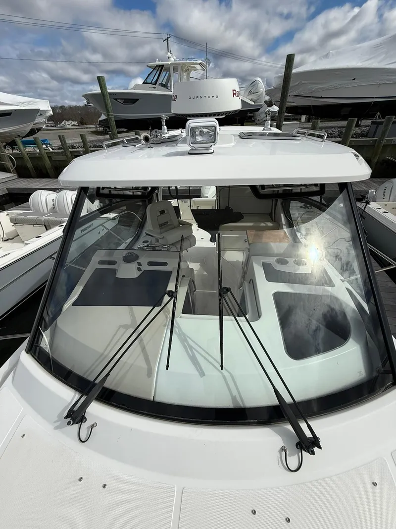 Slide: The Image of 2020 Boston Whaler 325 Conquest boat docked, showcasing windshield and cockpit area. - 32