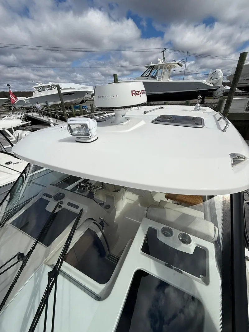 Slide: The Image of 2020 Boston Whaler 325 Conquest boat docked under cloudy skies. - 33