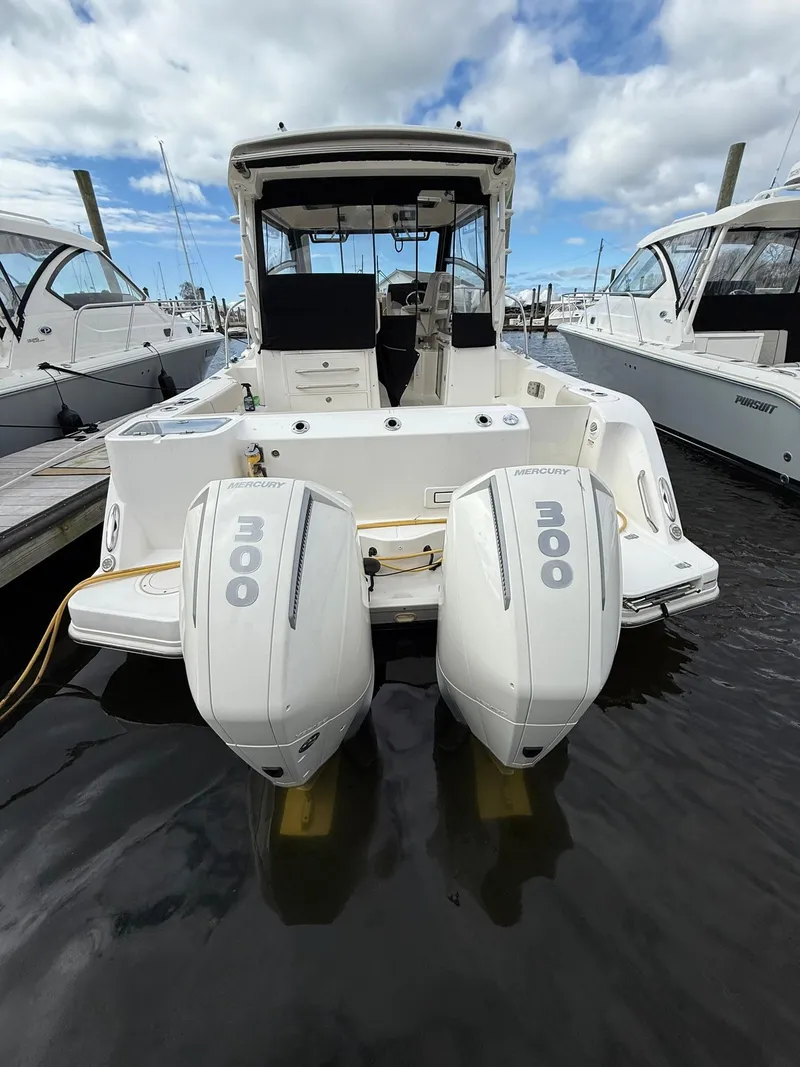 Slide: The Image of 2020 Boston Whaler 325 Conquest with twin outboard engines docked at marina. - 34