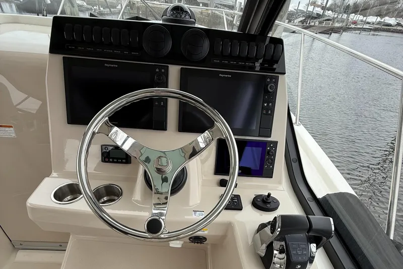 Slide: The Image of 2020 Boston Whaler 325 Conquest helm with dual screens and chrome steering wheel. - 35