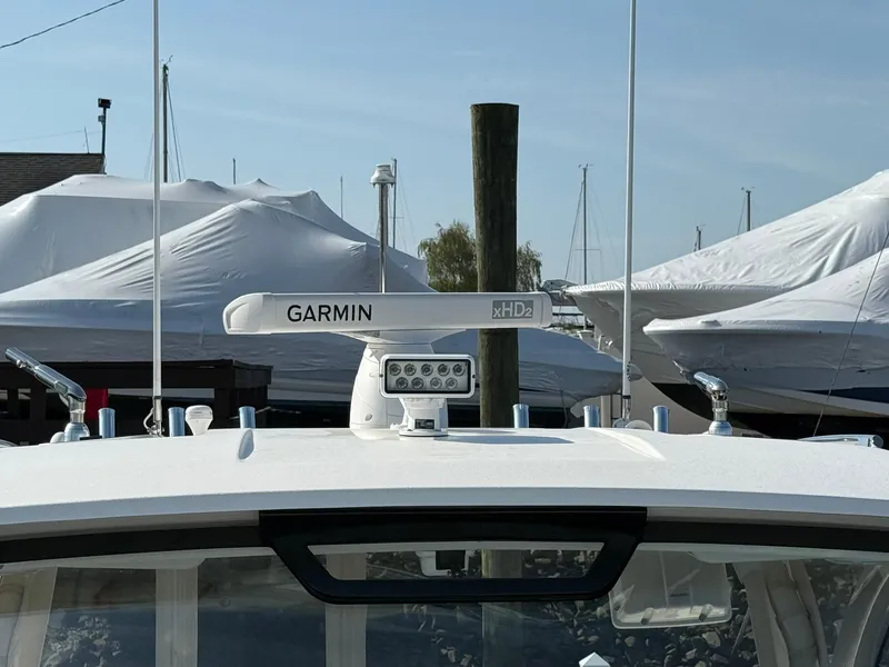 Slide: The Image of 2020 Boston Whaler 325 Conquest with Garmin radar, docked with covered boats in background. - 39
