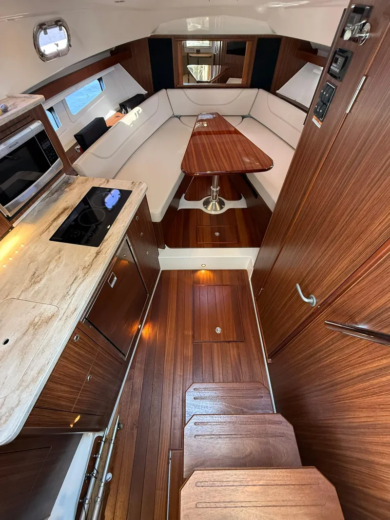Slide: The Image of 2020 Boston Whaler 325 Conquest interior with wood finish, kitchenette, and seating area. - 43