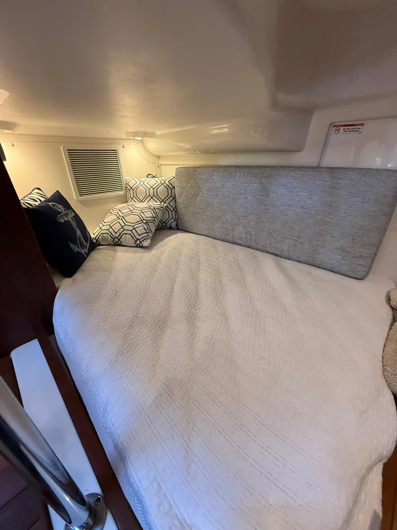 Slide: The Image of 2020 Boston Whaler 325 Conquest cabin interior with cozy bedding and cushions. - 45