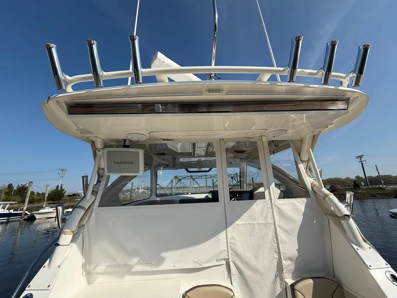 Slide: The Image of 2020 Boston Whaler 325 Conquest boat, rear view with fishing rod holders and canopy. - 47