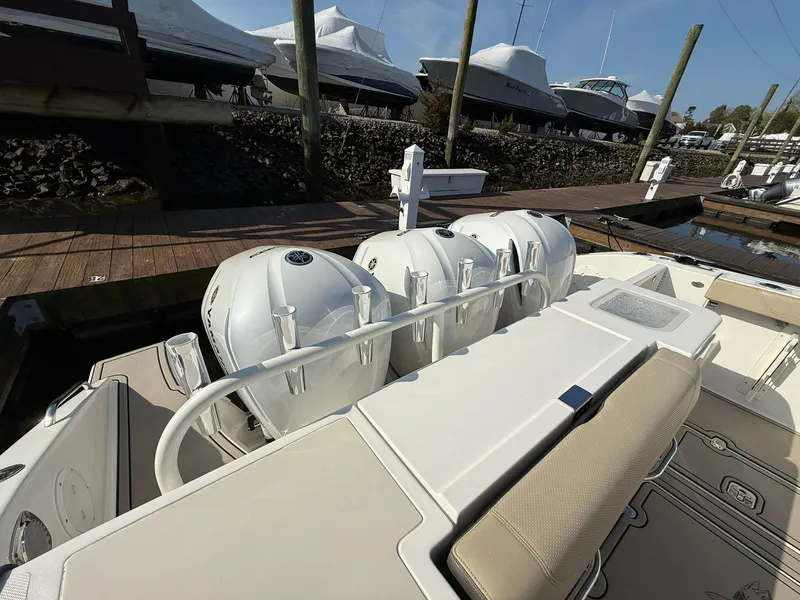 Slide: The Image of 2020 Boston Whaler 325 Conquest with triple outboard engines docked at marina. - 48