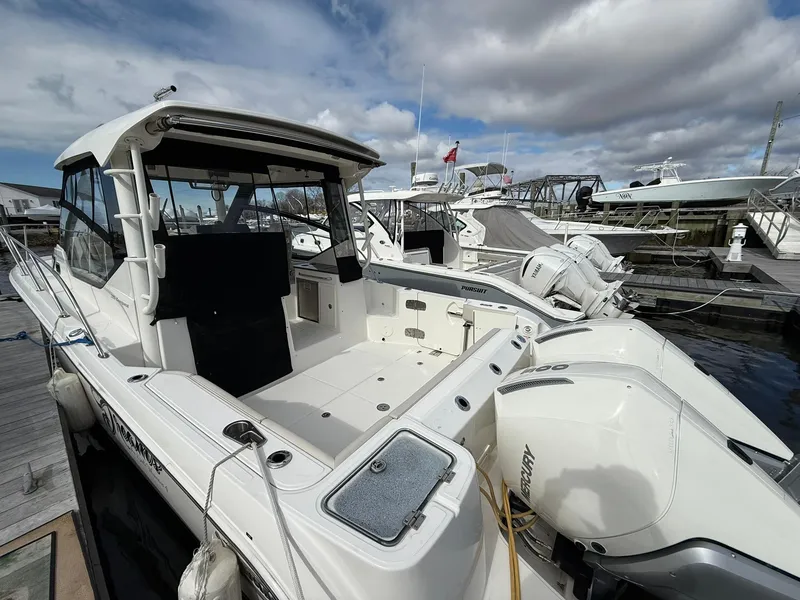 Slide: The Image of 2020 Boston Whaler 325 Conquest docked, showcasing spacious deck and dual outboard engines. - 6