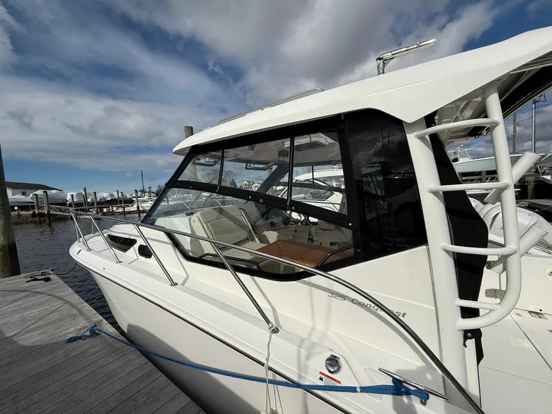 Slide: The Image of 2020 Boston Whaler 325 Conquest boat docked at marina under cloudy sky. - 7