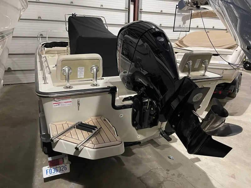Slide: The Image of 2024 Boston Whaler 190 Montauk boat with outboard motor in a garage setting. - 22