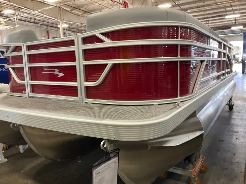 The Image of 2024 Bennington 20 SVSR SPS pontoon boat with red paneling in a warehouse setting. - 0