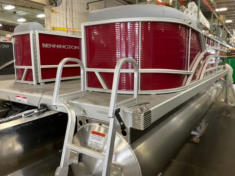 Slide: The Image of 2024 Bennington 20 SVSR SPS pontoon boat with red exterior in a factory setting. - 2