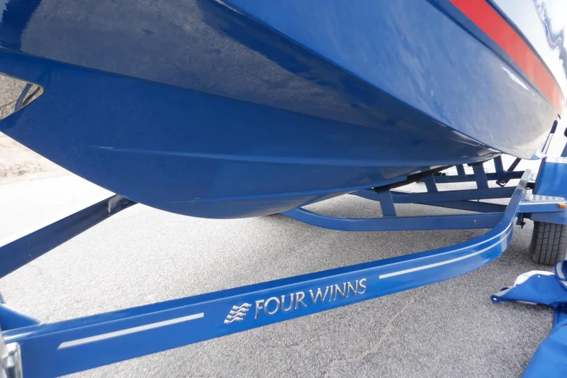 Slide: The Image of 2018 Four Winns HD200 boat on trailer, blue hull, close-up view. - 15