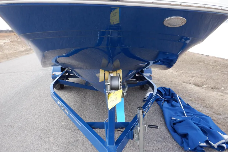 Slide: The Image of 2018 Four Winns HD200 boat on trailer, blue hull, parked on road. - 18