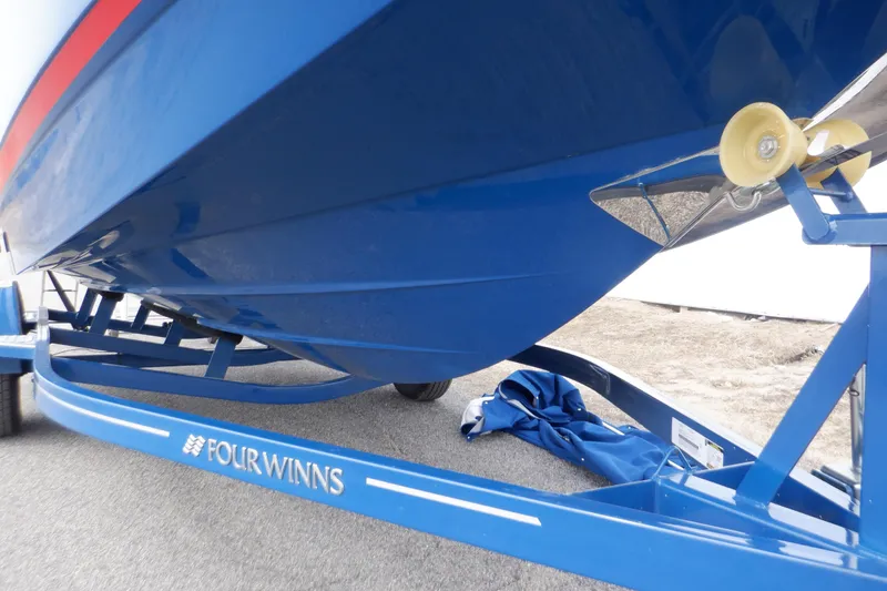 Slide: The Image of 2018 Four Winns HD200 boat on a blue trailer, close-up view. - 19