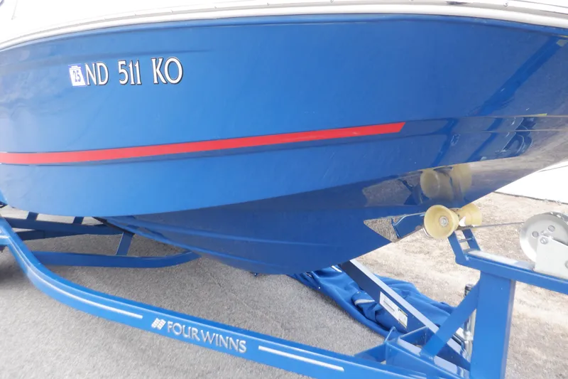 Slide: The Image of 2018 Four Winns HD200 boat on trailer, blue hull with red stripe. - 20