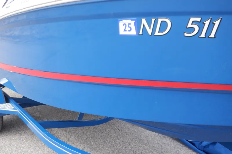 Slide: The Image of 2018 Four Winns HD200 boat with blue hull and red stripe on trailer. - 21