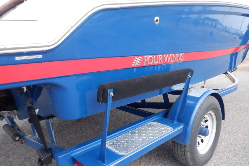 Slide: The Image of 2018 Four Winns HD200 boat on trailer, blue with red stripe, side view. - 25