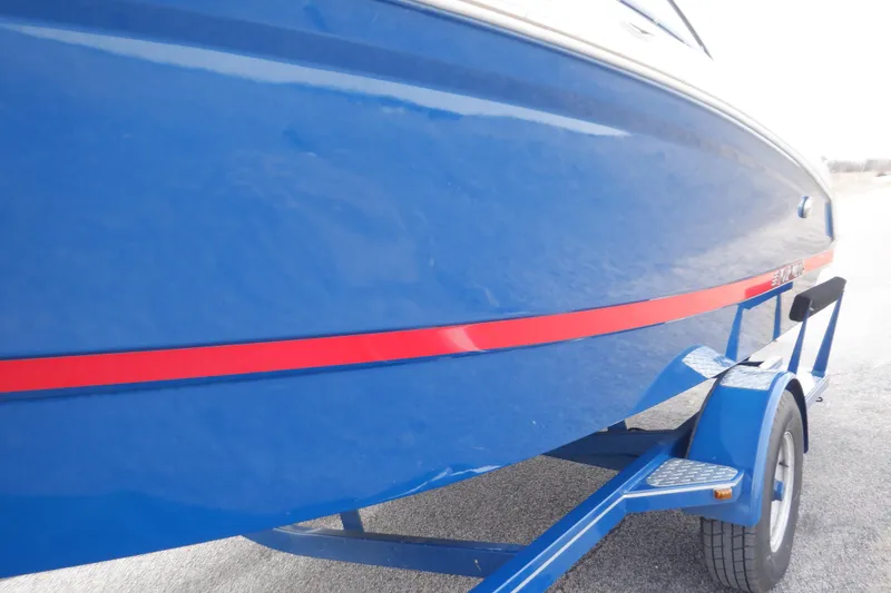 Slide: The Image of 2018 Four Winns HD200 boat with blue hull and red stripe on trailer. - 28