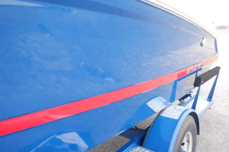 Slide: The Image of 2018 Four Winns HD200 boat, blue with red stripe, on trailer. - 29