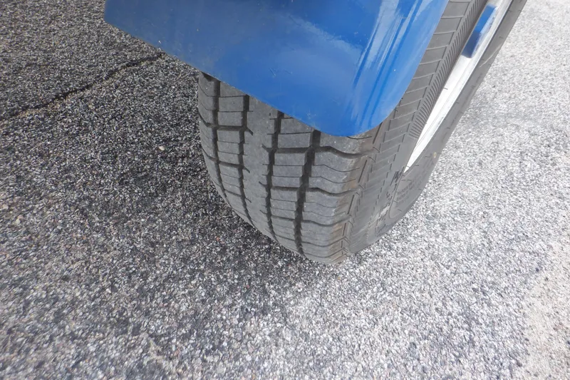 Slide: The Image of Tire of a 2018 Four Winns HD200 boat trailer on asphalt. - 31