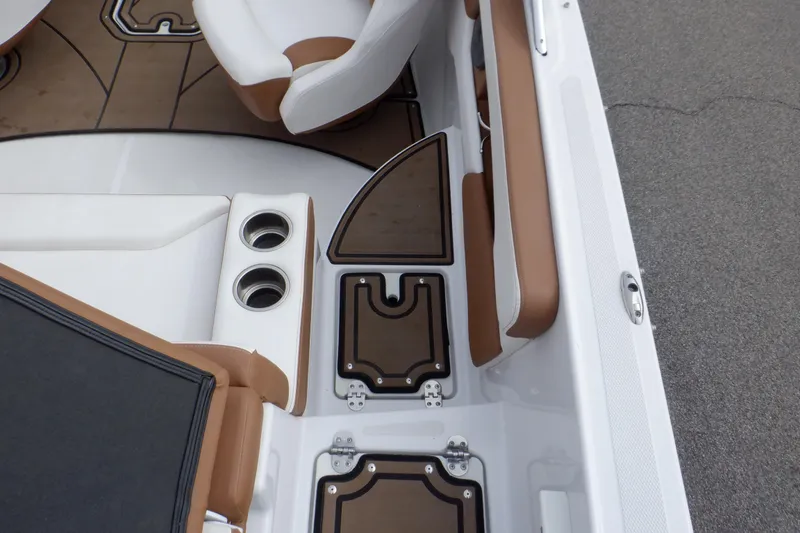 Slide: The Image of 2018 Four Winns HD200 boat interior with brown and white seating, cup holders, and storage compartments. - 37