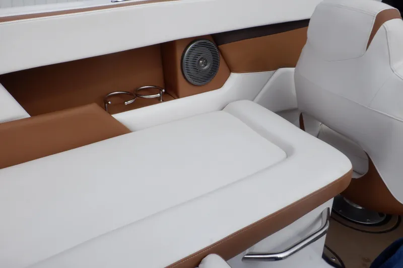 Slide: The Image of 2018 Four Winns HD200 boat interior with white and brown seating, cup holders, and speaker. - 50