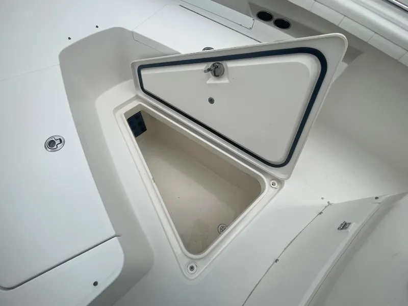 Slide: The Image of 2017 Regulator 23 FS Center Console boat storage compartment open. - 10