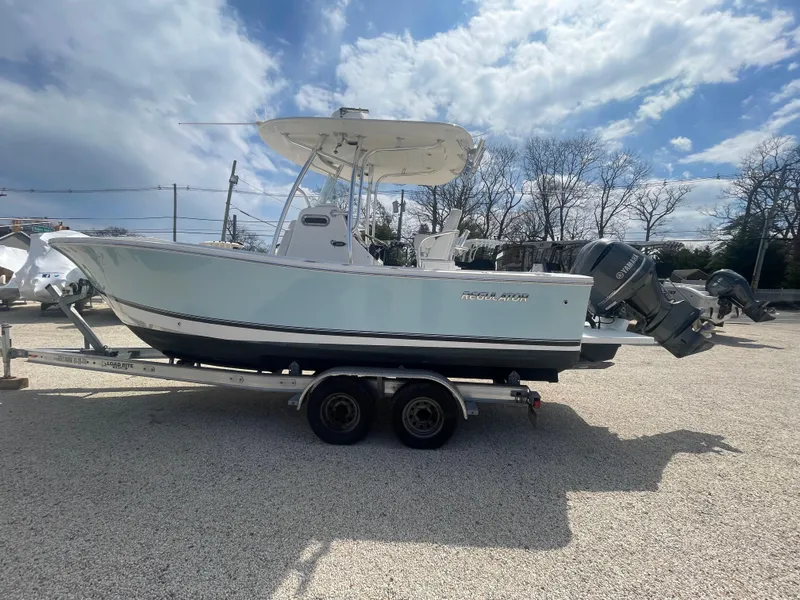 Slide: The Image of 2017 Regulator 23 FS Center Console boat on trailer under cloudy sky. - 3