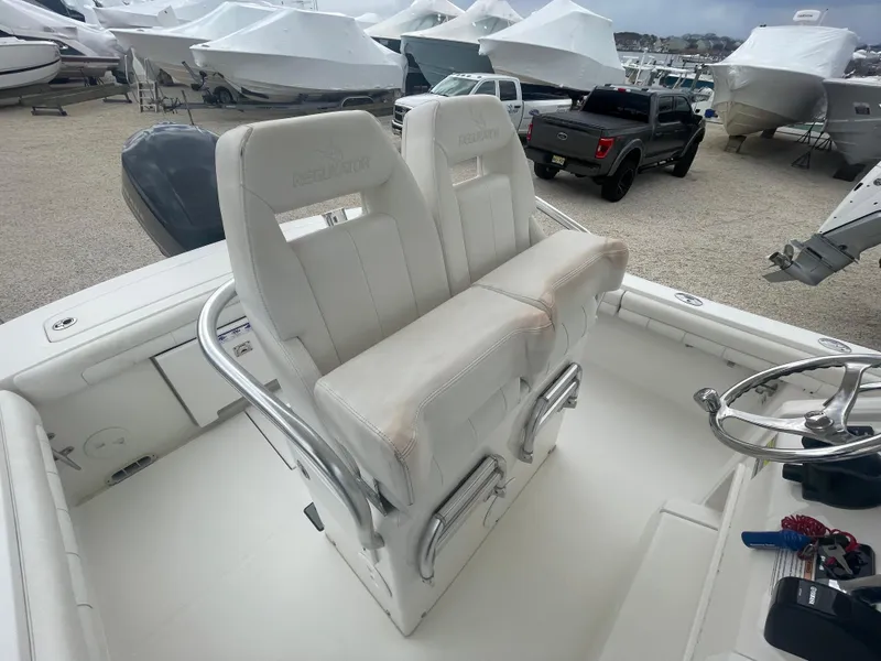 Slide: The Image of 2017 Regulator 23 FS boat with dual white captain's seats in a marina. - 31