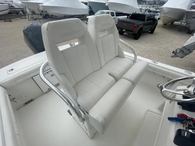 Slide: The Image of 2017 Regulator 23 FS boat with white cushioned seating and stainless steel railings. - 32
