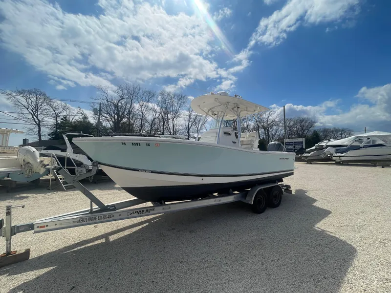 Slide: The Image of 2017 Regulator 23 FS Center Console boat on trailer under a sunny sky. - 4
