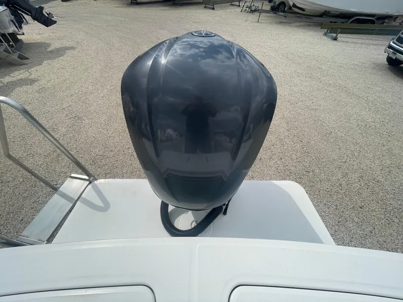 Slide: The Image of 2017 Regulator 23 FS boat with a sleek outboard motor, parked on gravel. - 43