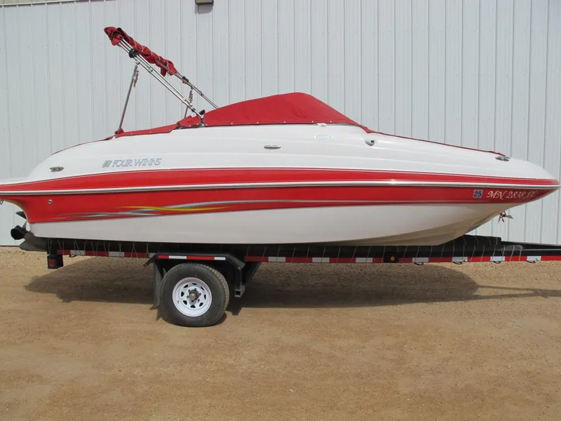 The Image of 2005 Four Winns 194 Funship boat with red cover on trailer, parked outdoors. - 1