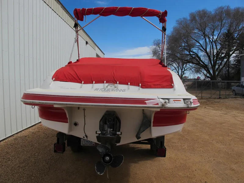 Slide: The Image of 2005 Four Winns 194 Funship boat with red cover, parked outdoors. - 3