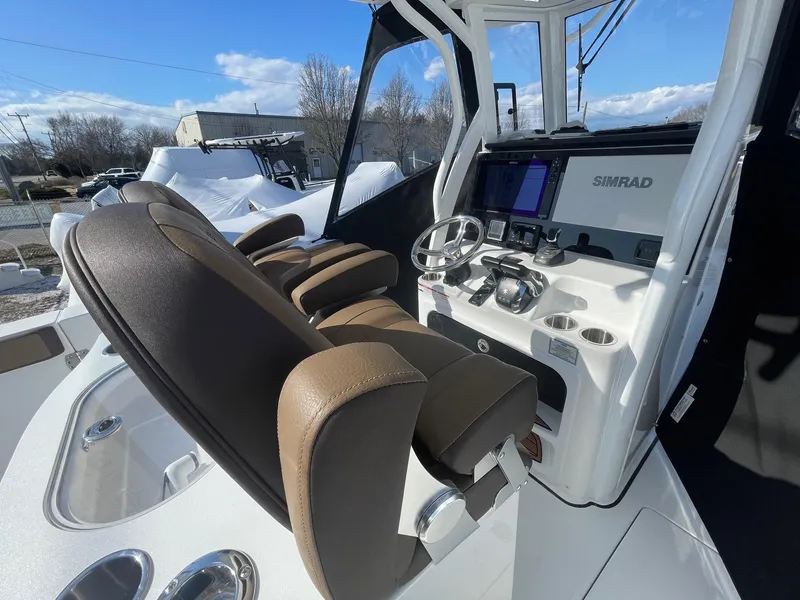 Slide: The Image of 2025 Sea Pro 292 Off Shore boat cockpit with brown seats and advanced navigation system. - 15