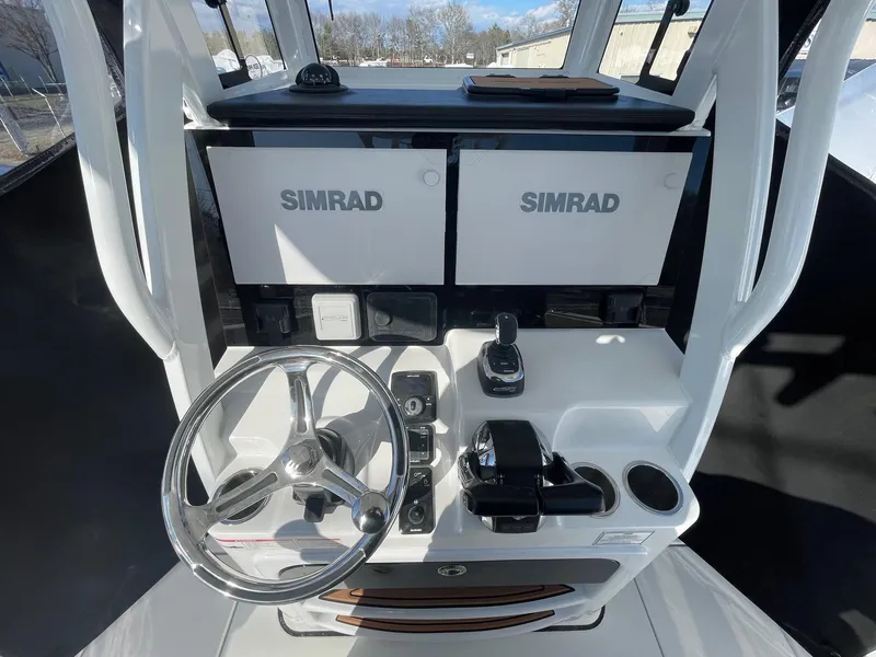 Slide: The Image of 2025 Sea Pro 292 Off Shore boat dashboard with dual Simrad displays and steering wheel. - 23