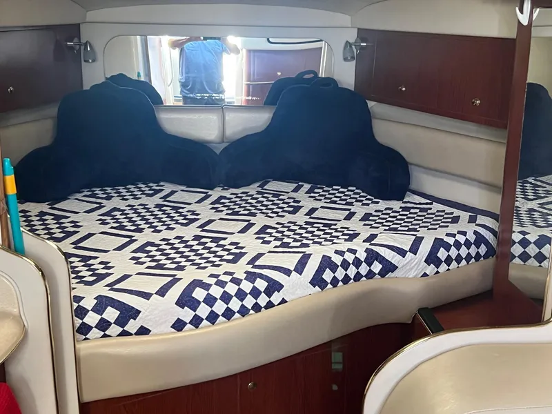 Slide: The Image of Interior cabin of 2001 Sea Ray 340 Amberjack with patterned bedding and wooden cabinets. - 17