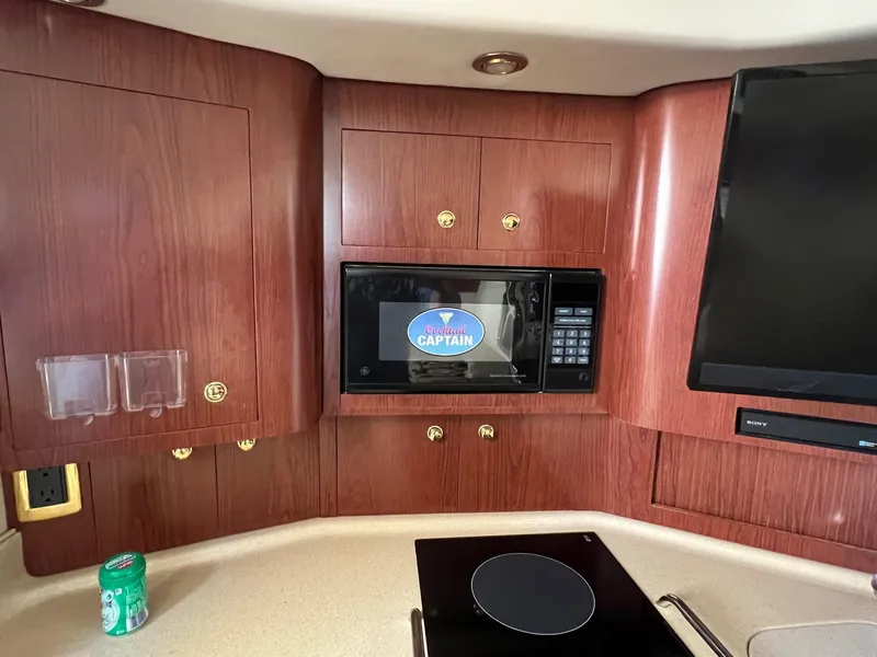 Slide: The Image of 2001 Sea Ray 340 Amberjack interior with microwave, stove, and wood cabinetry. - 20