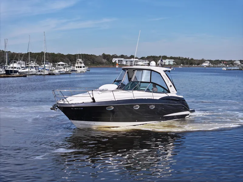 Slide: The Image of 2013 Monterey 340 Sport Yacht cruising on a calm lake with marina in background. - 10