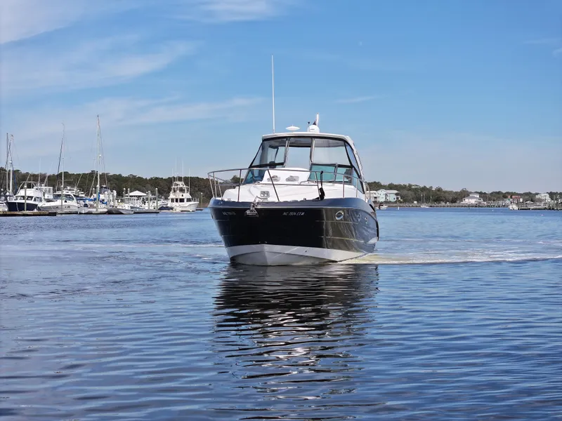 Slide: The Image of 2013 Monterey 340 Sport Yacht cruising on calm waters near a marina. - 12