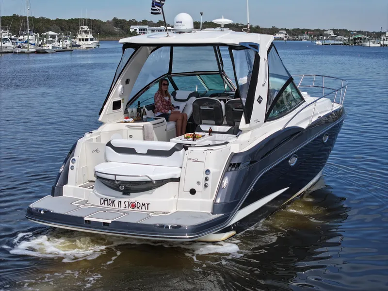 Slide: The Image of 2013 Monterey 340 Sport Yacht cruising on a calm lake with a person relaxing onboard. - 13