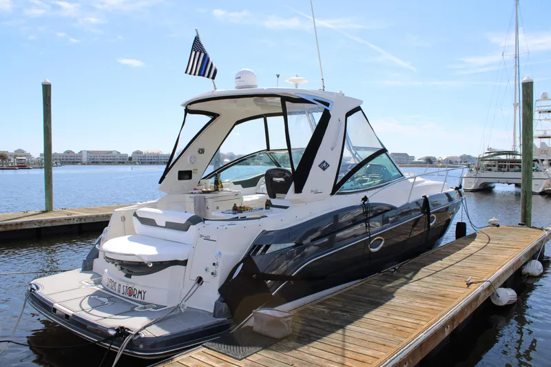 Slide: The Image of 2013 Monterey 340 Sport Yacht docked, featuring sleek design and American flag. - 14
