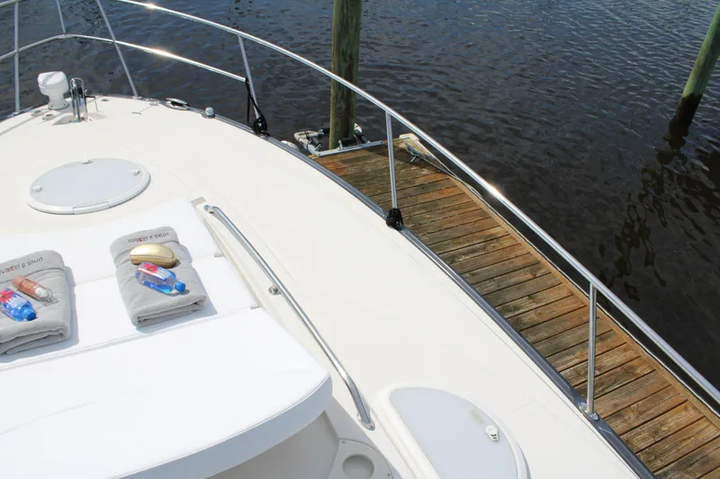 Slide: The Image of 2013 Monterey 340 Sport Yacht docked, featuring sunbathing area with towels and water bottles. - 27