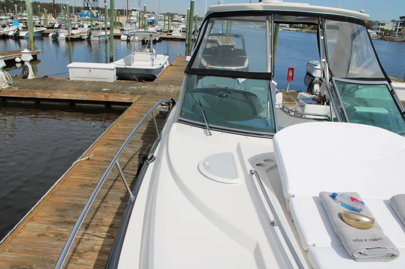 Slide: The Image of 2013 Monterey 340 Sport Yacht docked at a marina, showcasing sleek design and spacious deck. - 29