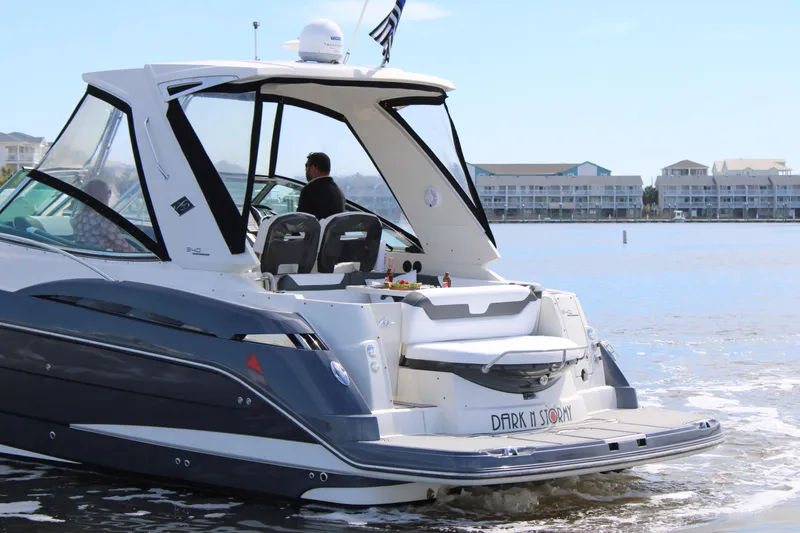 Slide: The Image of 2013 Monterey 340 Sport Yacht cruising on calm waters near coastal buildings. - 3
