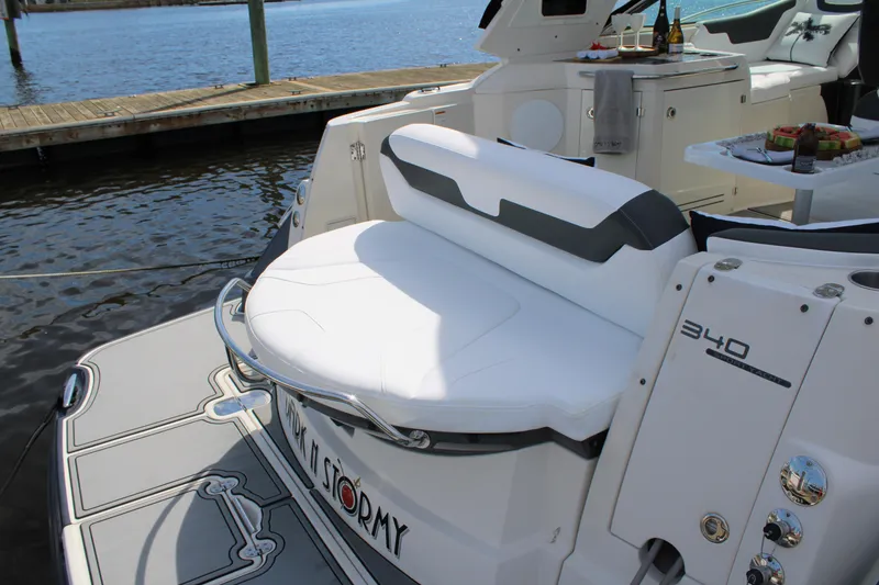 Slide: The Image of 2013 Monterey 340 Sport Yacht, rear seating area, docked by the water. - 41
